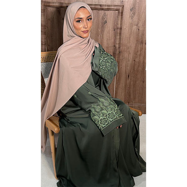 A women Wearing A Sage Shiny Satin Fabric Open Button Abaya with side pockets and elegant  well detailed floral embroidery Size 52 